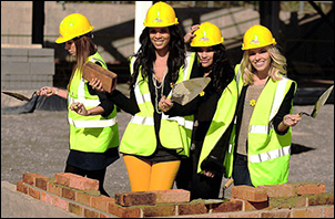 [Women building brick walls]